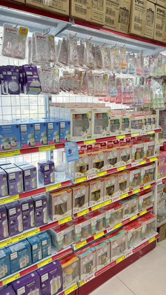 ชั้นวางขวดนมและอุปกรณ์ป้อนนมหลายยี่ห้อ วางเทียบกันให้เลือกที่หน้าร้าน เชียงใหม่